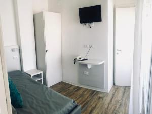 Piccola camera con letto e TV a parete di Hotel Nelson a Rimini