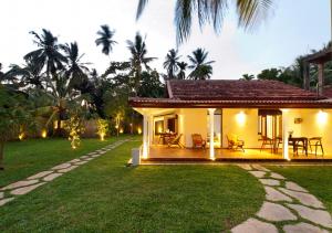 a house with a patio and a grass yard at Fantasea in Mirissa