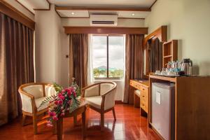 a kitchen with a table and chairs and a window at Sakura Princess Hotel in Mandalay