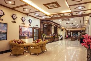 a lobby with chairs and tables in a building at Sakura Princess Hotel in Mandalay