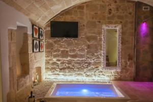 een bad in een kamer met een stenen muur bij SUITE 31 in Monopoli
