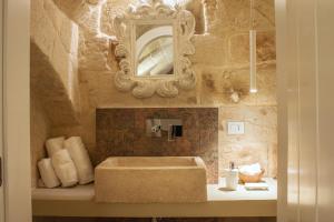 bagno con lavandino, specchio e asciugamani di SUITE 31 a Monopoli