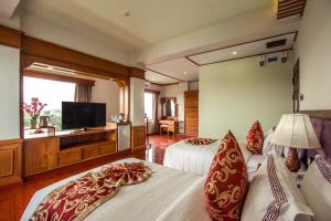 a hotel room with two beds and a flat screen tv at Sakura Princess Hotel in Mandalay