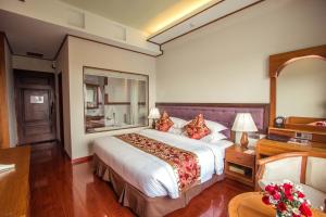 a hotel room with a large bed and a mirror at Sakura Princess Hotel in Mandalay +88 photos