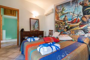 1 dormitorio con 2 camas y una gran pintura en la pared en Calagonone villetta con giardino e barbecue, en Cala Gonone