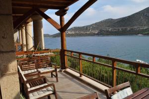 a balcony with chairs and a view of the water at Into The Blue Apartment in Áyios Andréas