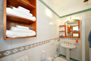a bathroom with a sink and a toilet and a mirror at Appartamenti Villa Maria in Ischia +22 photos