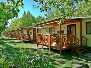 a row of cottages with tables and chairs at Campeggio Gasparina in Castelnuovo del Garda