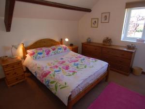 a bedroom with a bed and a dresser at Jacobs Barn in Lifton