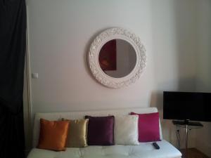 a mirror on a wall above a couch with pillows at Whatever Art B&B in Lisbon