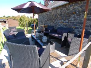 a patio with chairs and a table and an umbrella at Jacobs Barn in Lifton
