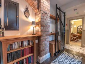a home library with bookshelves and a brick wall at The Cells in Ingleton 