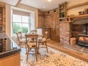 a kitchen with a table and a fireplace at Magistrates Chambers in Ingleton 