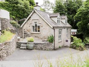 una vecchia casa in pietra con un muro di pietra di Honeypot Cottage a Kendal