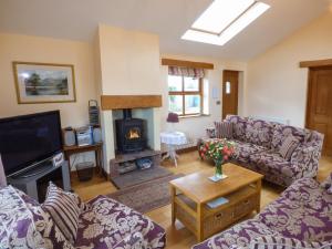 a living room with couches and a fire place at Sunny Hill in Penrith