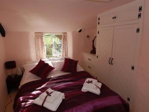 a bedroom with a bed with towels on it at Appletree Cottage in Ilsington