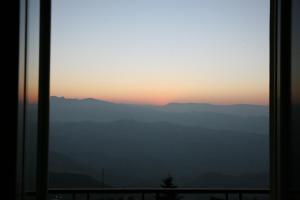 una ventana con vistas a las montañas al atardecer en Hotel Rosa, en San Marino