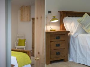 Fritillary Cottage في Bradworthy: غرفة نوم مع سرير وخزانة مع مصباح