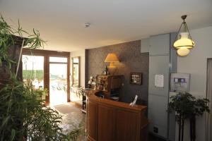 a room with a hallway with a desk and a lamp at Beaune Hôtel in Beaune