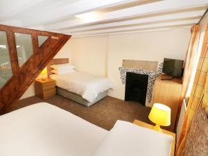 um quarto com 2 camas e uma lareira em Mill View Cottage em Belper