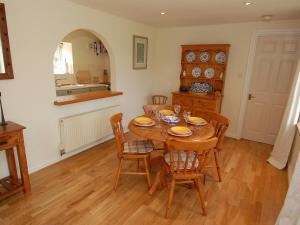 a dining room with a wooden table and chairs at Acorn Cottage in Bruton