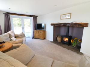 a living room with a couch and a fireplace at Damson Barn in Casterton