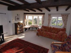 een woonkamer met een bank en een tafel bij Appletree Cottage in Ilsington