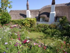 einen Garten vor einem Gebäude mit Blumen in der Unterkunft Appletree Cottage in Ilsington