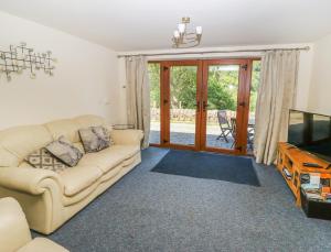 a living room with a couch and a tv at Hove Wood View in Hebden Bridge