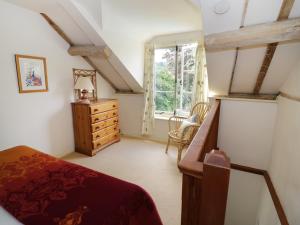 a bedroom with a bed and a dresser and a window at The Cottage in Pershore