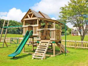 a wooden playground with a slide and a ladder at Valley Lodge 48 in Callington