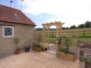 a garden with a wooden gate and a fence at Acorn Cottage in Bruton