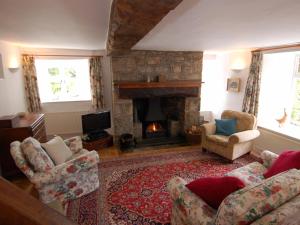 a living room with a couch and a fireplace at Thorn Cottage in Chagford