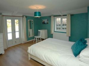 a bedroom with a white bed and blue walls at Old Lyn Cottage in Lynmouth