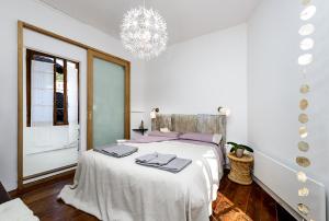 a white bedroom with a large bed with purple pillows at Al vicolo del Gallo in Varallo