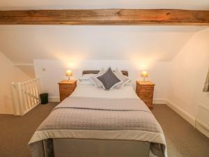 a bedroom with a large bed with two night stands at Farley Cottage I in Oakamoor