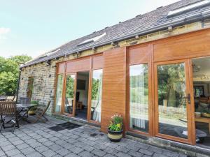 a house with glass doors and a patio at Hove Wood View in Hebden Bridge