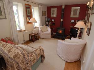 a living room with a couch and chairs and a fireplace at Acorn Cottage in Bruton