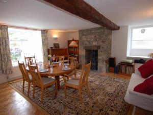 a dining room with a table and chairs and a fireplace at Thorn Cottage in Chagford