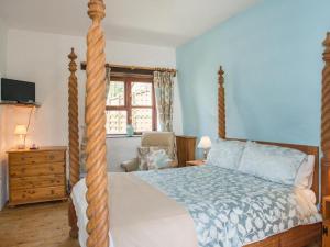 1 dormitorio con cama con dosel y poste de madera en Billy's Barn, en Bradworthy