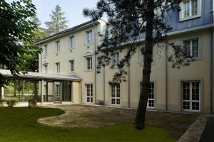 un grand bâtiment blanc avec un arbre en face dans l'établissement Meditur Hotel Bologna, à Bologne