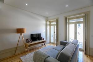 a living room with a couch and a tv at Cedofeita Bohemian Lifestyle Apartment in Porto