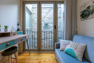 salon z niebieską kanapą i biurkiem w obiekcie Cedofeita Bohemian Lifestyle Apartment w Porto