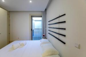 sypialnia z białym łóżkiem i ręcznikami w obiekcie Cedofeita Bohemian Lifestyle Apartment w Porto
