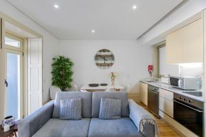 salon z niebieską kanapą w kuchni w obiekcie Cedofeita Bohemian Lifestyle Apartment w Porto