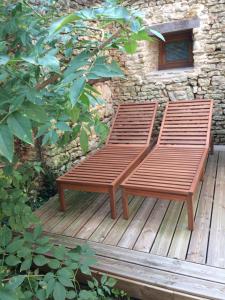 two wooden benches sitting on a wooden deck at Petite escale Vivonnoise a 2 in Vivonne