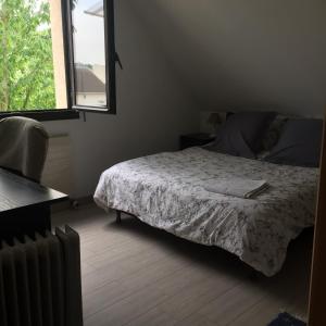 a bedroom with a bed and a window and a radiator at Cheng in Saint-Germain-en-Laye