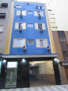 un edificio azul con ventanas blancas en una calle en Hotel Ideal Flíper com Estacionamento Grátis para carro pequeno altura padrão "INTERNET FIBRA", en São Paulo