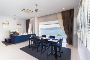 a dining room with a table and chairs and a large window at Jirana Patong in Patong Beach