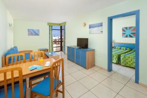 a room with a dining table and a bedroom at Paraiso del Sol y Paradero in Playa de las Americas